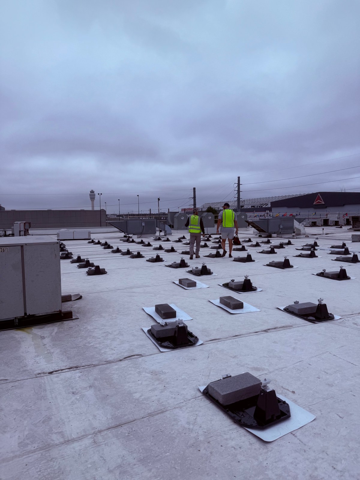First Class Roofing crew installing solar panels on a flat roof